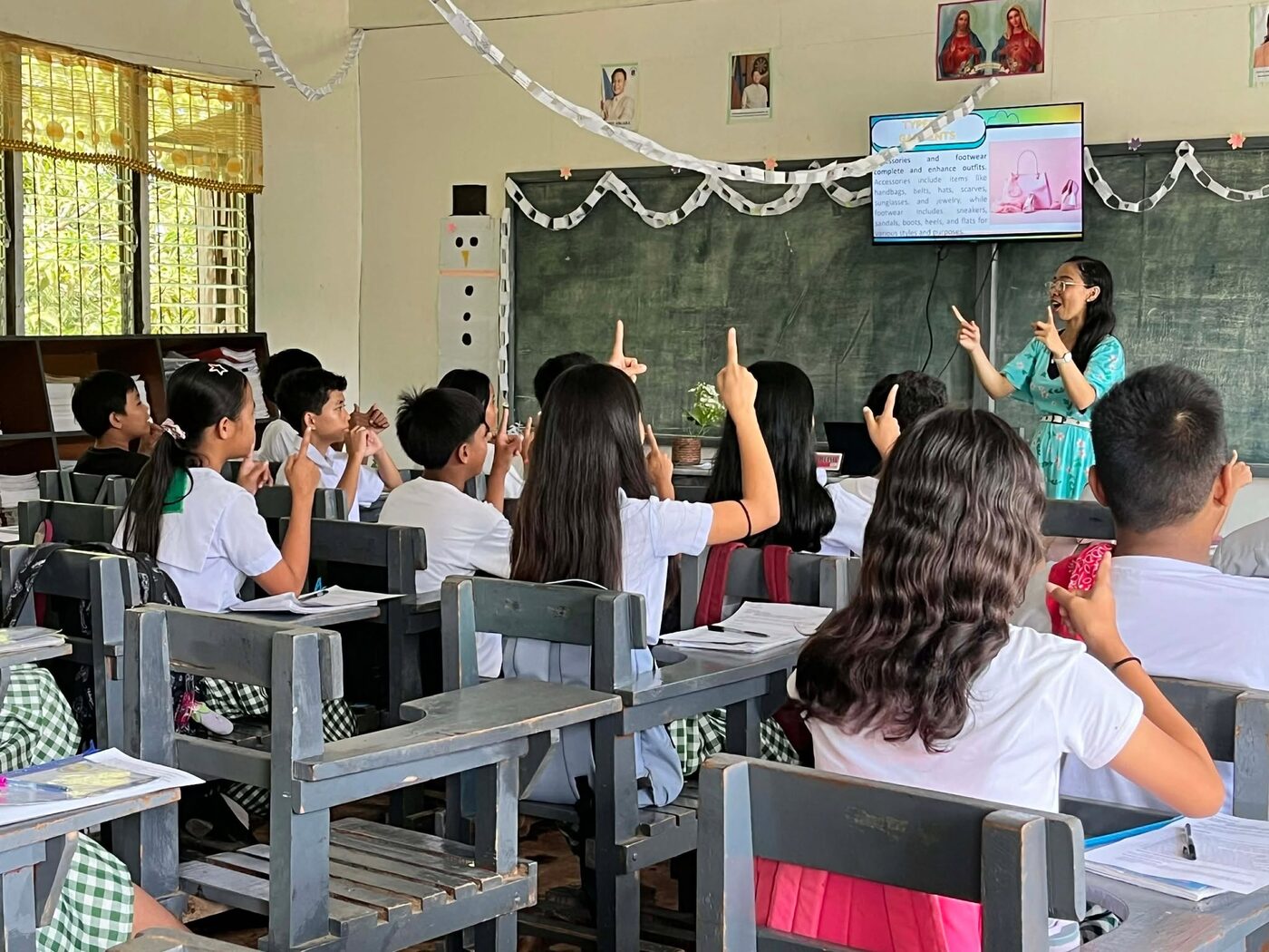 Schoolchildren raising their hands during a gospel lesson in a public school classroom in Alicia